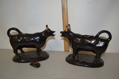 Lot 183 - A pair of Jackfield type black and gilt cow...