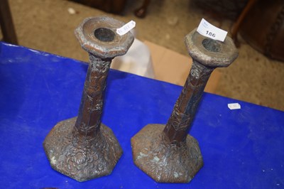 Lot 186 - A pair of Chinese alloy candlesticks decorated...