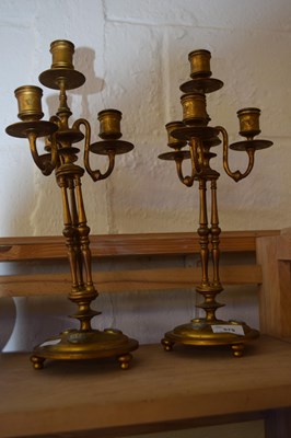 Lot 575 - A pair of brass four branch candelabra each...