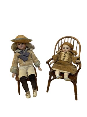 Lot 223 - A pair of small bisque head dolls on wooden...