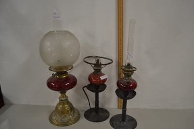 Lot 217 - Three oil lamps with ruby glass fonts