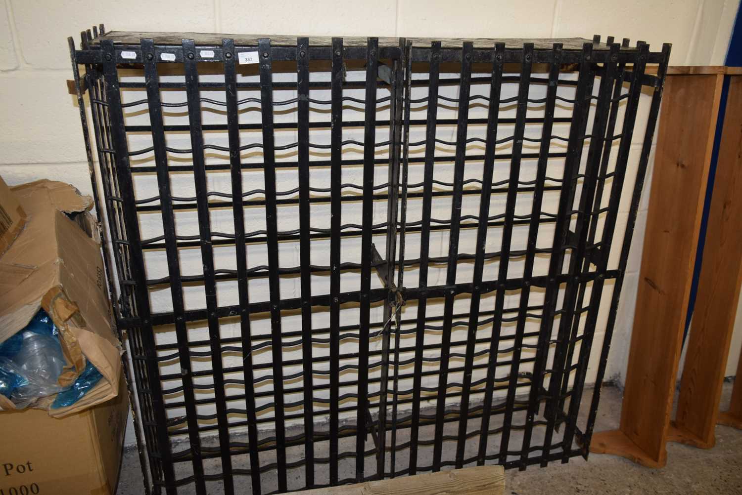 Lot 382 An iron wine rack with lockable doors