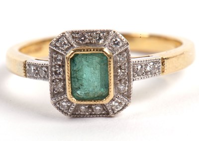 Lot 23 - An 18ct emerald and diamond ring, the central...