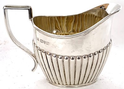 Lot 30 - Edwardian silver cream jug of oval form, half...