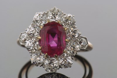 Lot 314 - A ruby and diamond cluster ring, the oval claw...