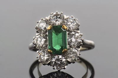 Lot 316 - An emerald and diamond cluster ring, the...