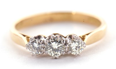 Lot 28 - A three stone diamond ring, the three round...
