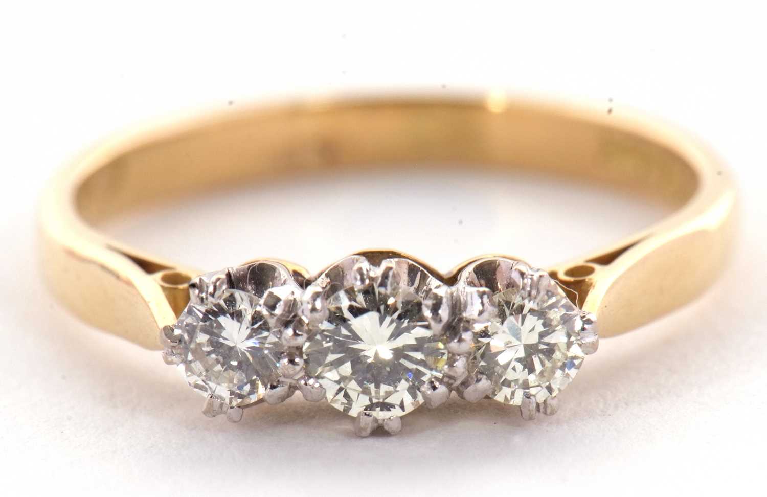 Lot 28 - A three stone diamond ring, the three round...