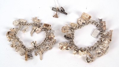 Lot 221 - Two silver charm bracelets, both with curblink...