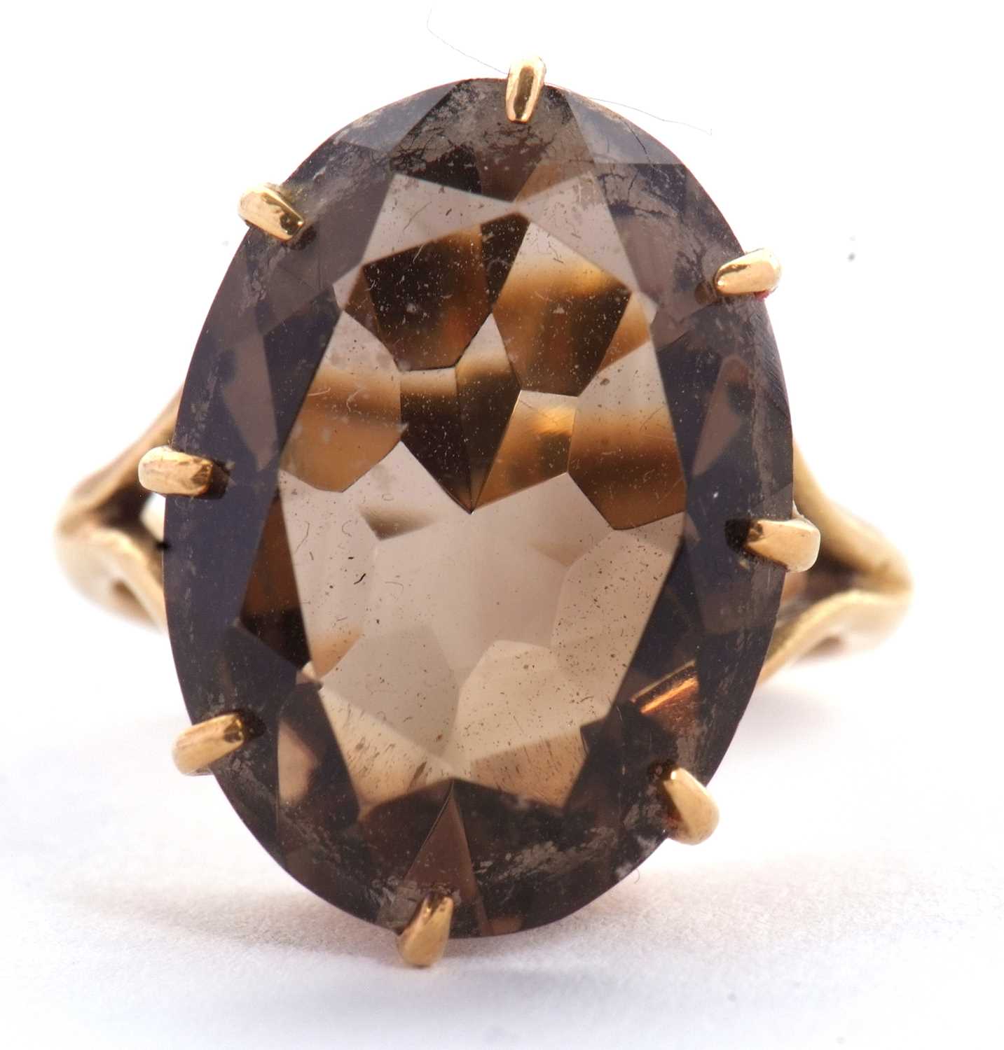 Lot 29 - A smokey quartz ring, the oval mixed cut...