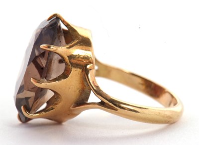 Lot 29 - A smokey quartz ring, the oval mixed cut...