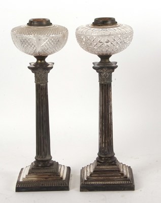 Lot 171 - Two silver plated Corinthian column oil lamps...