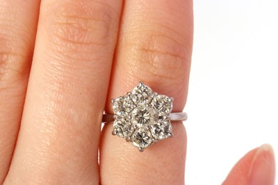 Lot 373 - A diamond flowerhead cluster ring, the central...