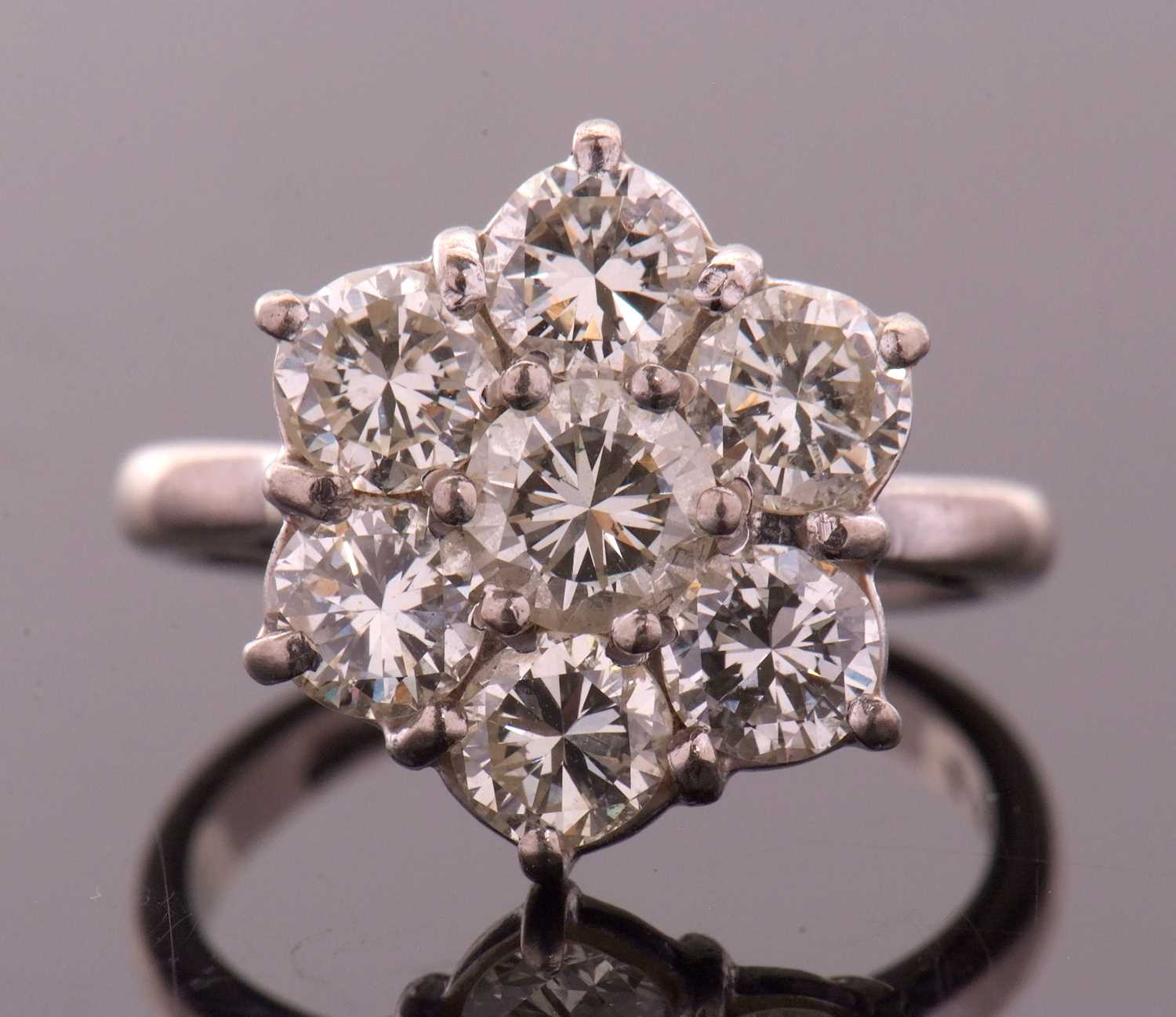 Lot 373 - A diamond flowerhead cluster ring, the central...