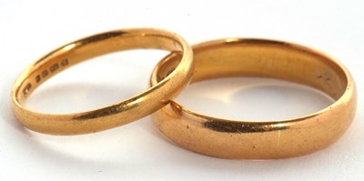 Lot 181 - Two 22ct gold rings: one 4.5mm wide,...