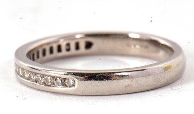 Lot 47 - A platinum half eternity ring, with channel...