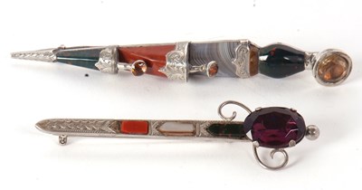 Lot 101 - Two agate kilt pins, one in the shape of a...