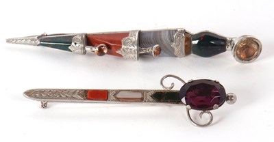 Lot 101 - Two agate kilt pins, one in the shape of a...