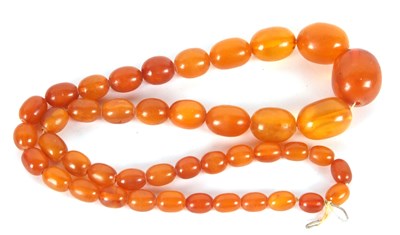 Lot 227 - An amber bead necklace, the graduated oval...