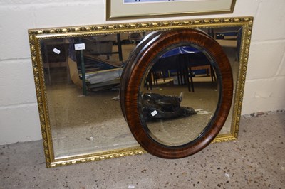 Lot 284 - An oval bevelled wall mirror in mahogany...