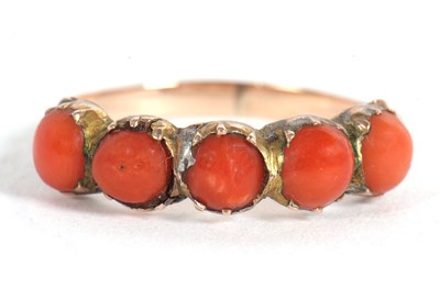 Lot 17 - A coral ring, the five round coral cabochons...