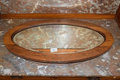 Lot 362 - An oval bevelled wall mirror in oak frame