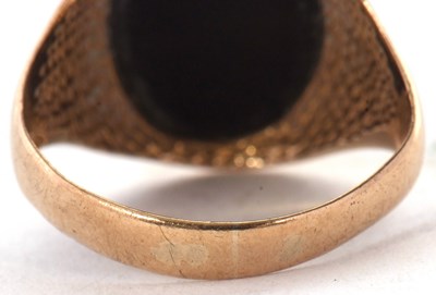 Lot 26 - A 9ct ring, set with an oval onyx disc, with...