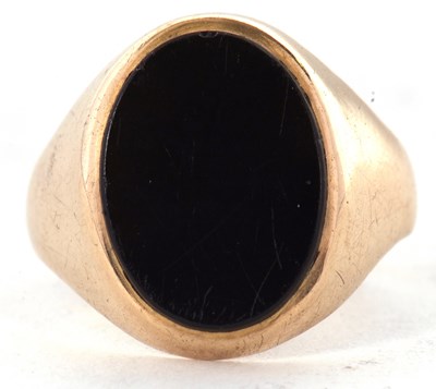 Lot 26 - A 9ct ring, set with an oval onyx disc, with...