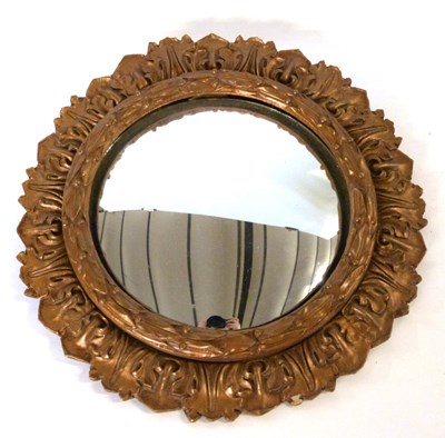 Lot 560 - A decorative convex mirror with carved petal...