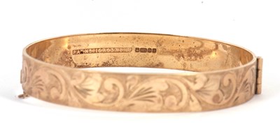 Lot 105 - A 9ct bangle, with engraved decoration...