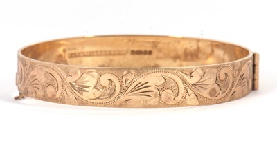 Lot 105 - A 9ct bangle, with engraved decoration...
