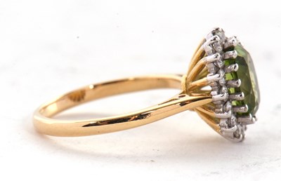 Lot 25 - An 18ct peridot and diamond cluster ring, the...