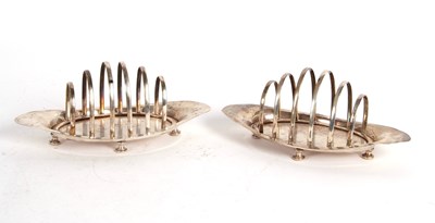 Lot 186 - A pair of Edwardian silver toast racks, boat...