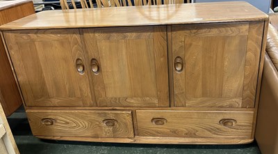 Lot 203 - An Ercol light elm sideboard with three doors...