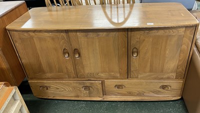 Lot 203 - An Ercol light elm sideboard with three doors...