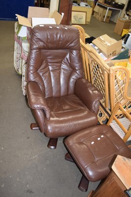 Lot 831 - A brown leather easy chair and footstool