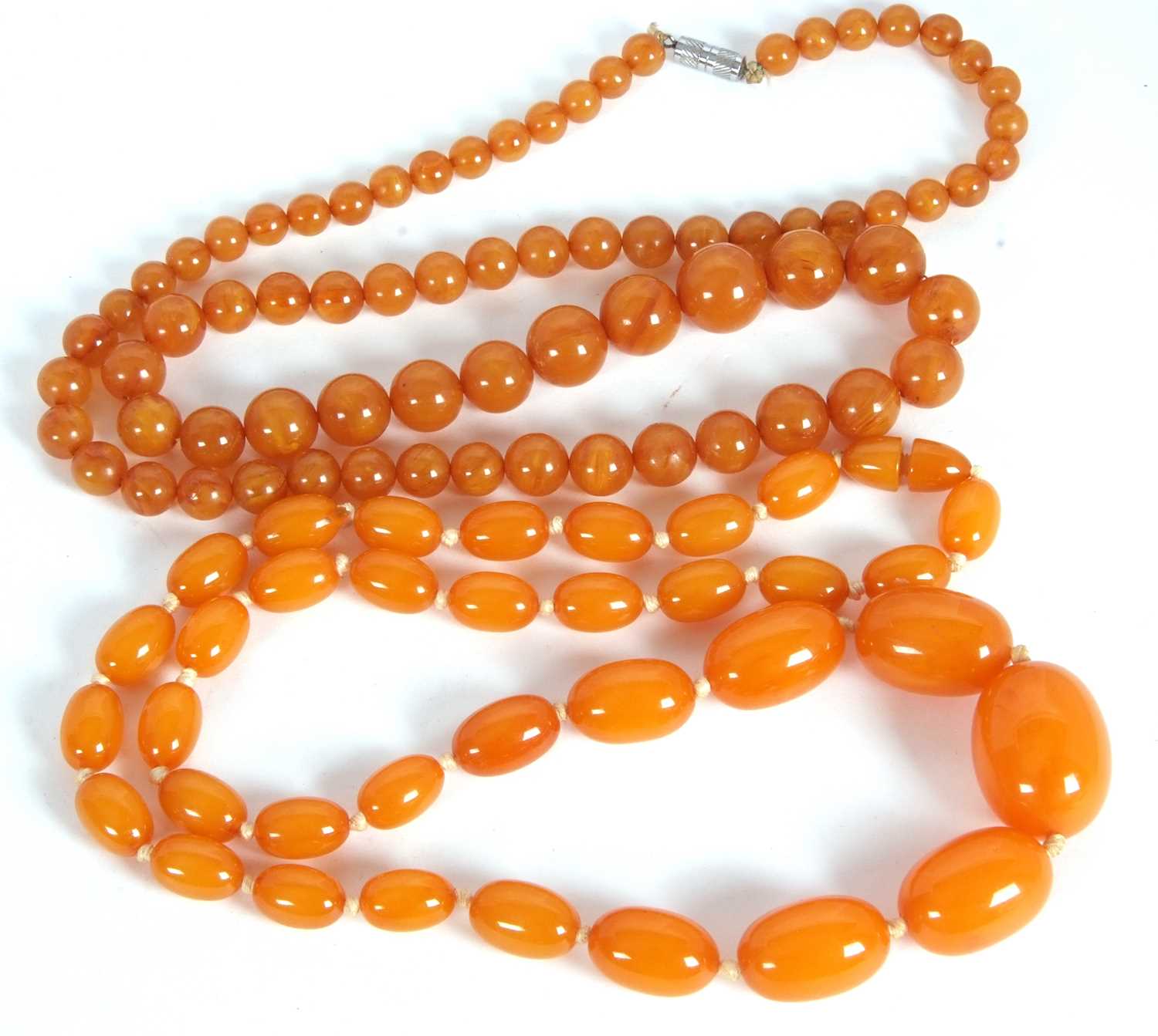 Lot 143 - Two faux butterscotch amber bead necklace, the...