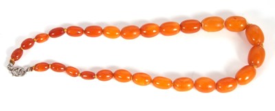 Lot 138 - A butterscotch amber bead necklace, the oval...