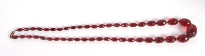 Lot 136 - A 'cherry amber' bead necklace, the oval...