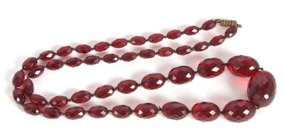 Lot 136 - A 'cherry amber' bead necklace, the oval...