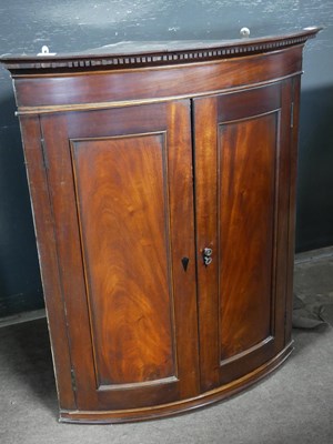 Lot 492 - Georgian mahogany bow front corner cabinet...