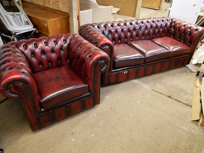 Lot 570 - Red leather Chesterfield three seater sofa...