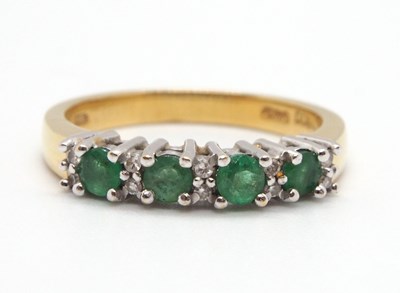 Lot 18 - An 18ct emerald and diamond ring, set with...