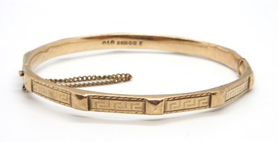 Lot 169 - A 9ct gold bangle, the 5.5mm wide bangle with...