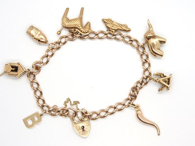 Lot 161 - A 9ct charm bracelet, the curlink bracelet...