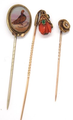 Lot 123 - Three stick pins: to include a carved coral...