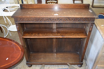 Lot 330 - An oak open front bookcase cabinet with carved...