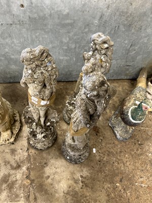 Lot 1080 - Three composite garden statues formed as...