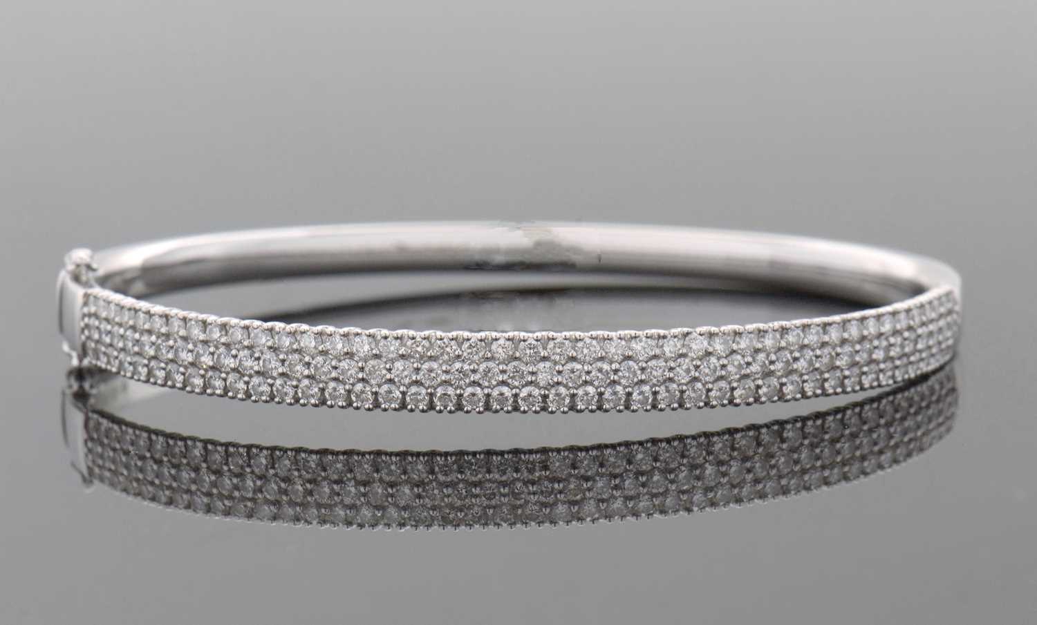 Lot 362 - An 18ct diamond bangle, the white gold hinged...