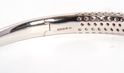 Lot 362 - An 18ct diamond bangle, the white gold hinged...